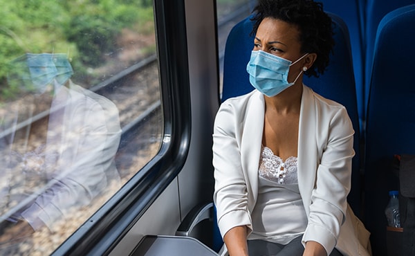 woman on train wearing a mask