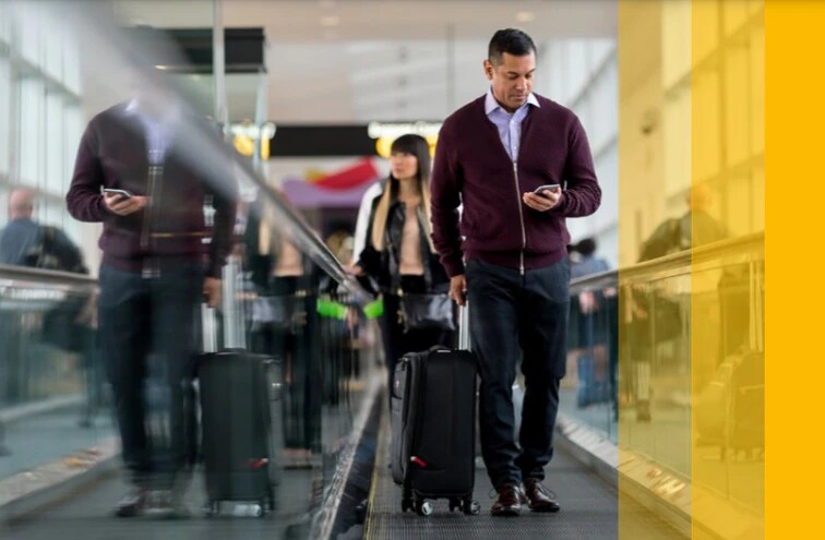 Man on travelator looking at mobile 