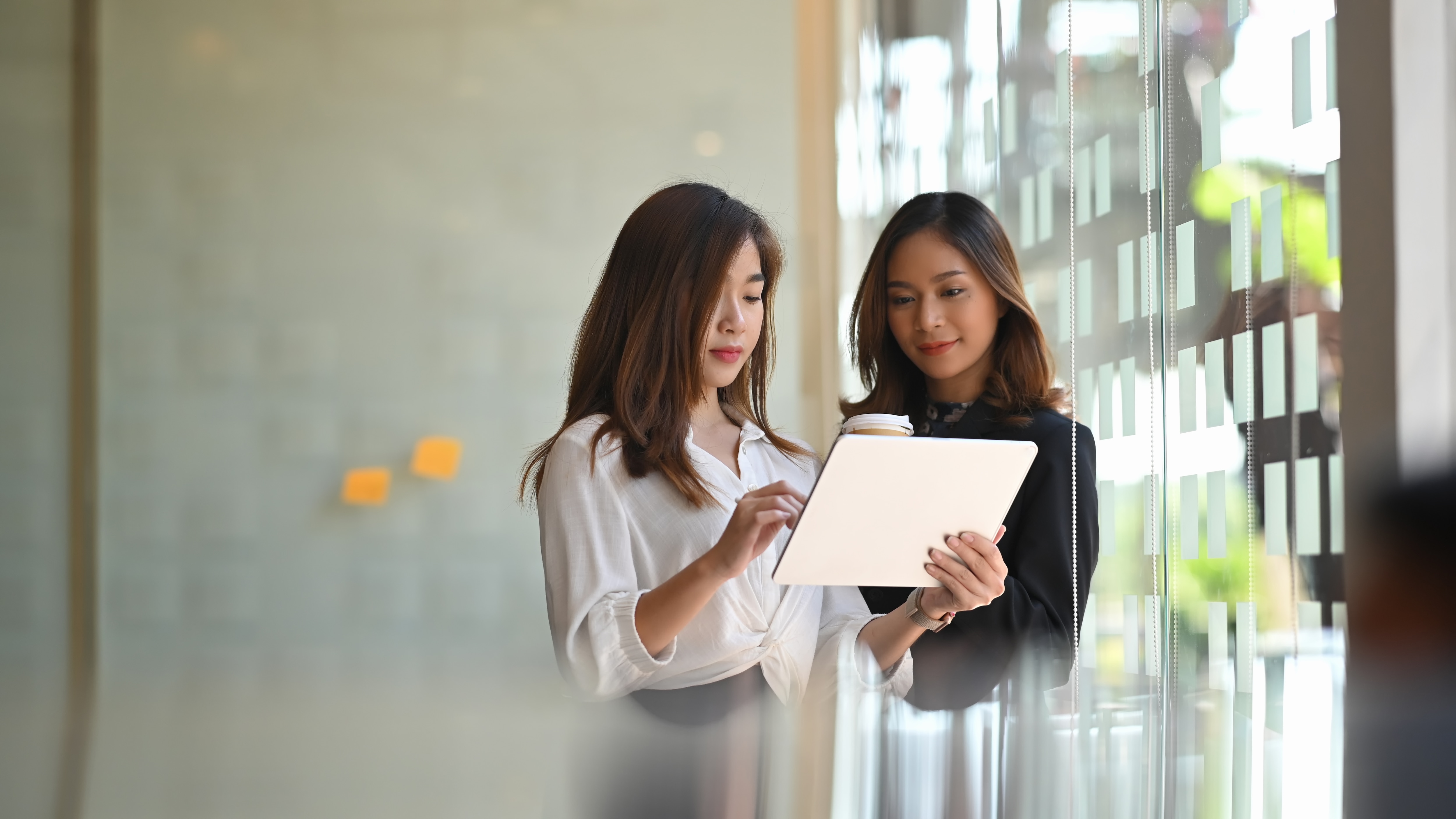 Two businesswomen looking at a tablet together